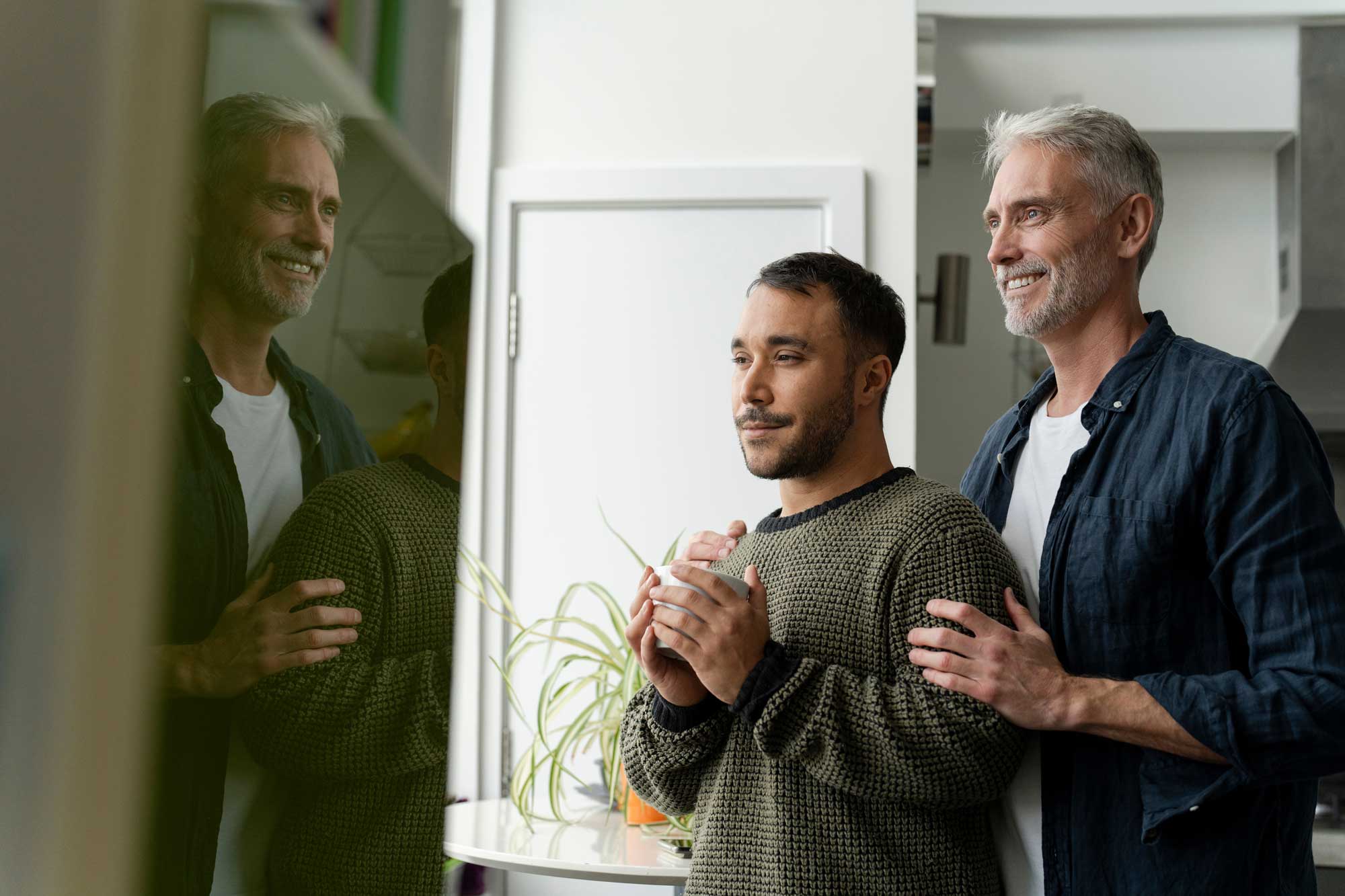 mature-male-couple-looking-through-window-at-home