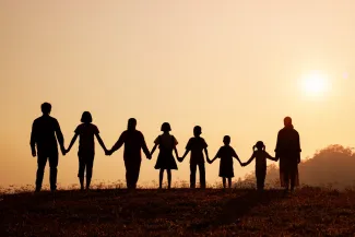 Silhouette of happy family standing on the mountain