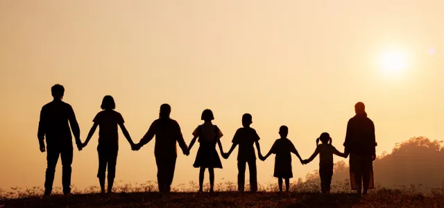 Silhouette of happy family standing on the mountain